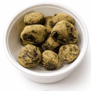 Bhang Goli herbal edibles in a white bowl, pack of 15 pieces for wellness.